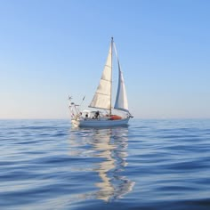 a sailboat sailing in the ocean on a clear day with no one around it