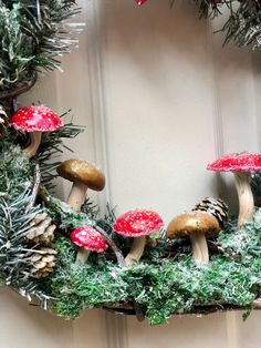 a wreath decorated with mushrooms and pine cones