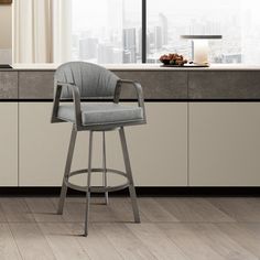 a gray bar stool sitting in front of a kitchen counter top next to a window