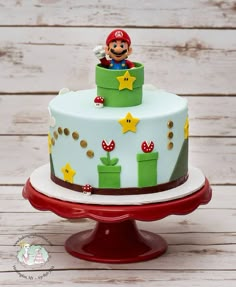 a birthday cake decorated with an image of mario on the top and stars around it