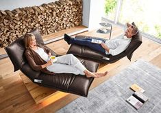 a man and woman sitting on recliners in the living room