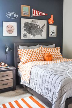 a bedroom decorated in orange and gray with pictures on the wall