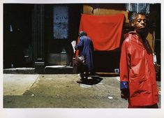 a man in a red coat standing next to a woman