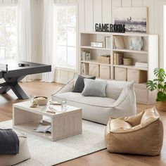 a living room filled with furniture and a book shelf next to a table in front of a window