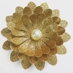 a gold flower with a pearl in the center