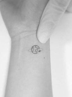 a small wrist tattoo with the earth on it