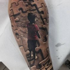 a man with a puzzle piece tattoo on his arm