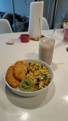 a white bowl filled with food on top of a table next to a glass of milk