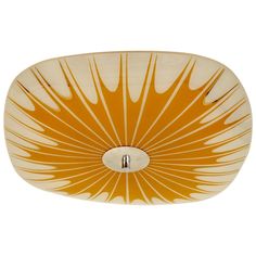 an orange and white glass bowl shaped like a sunburst on a white background