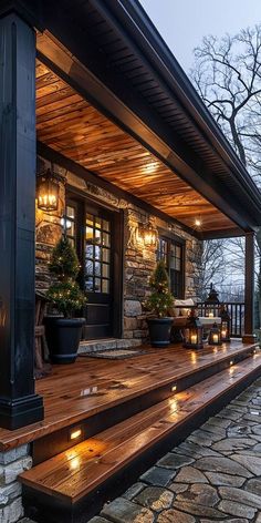 a stone house with lights on the front porch