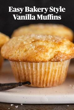 some muffins are sitting on a plate with cinnamon sticks in front of them