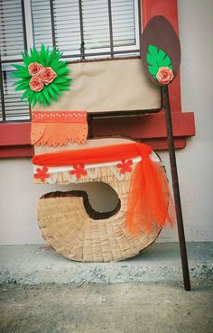 a wooden sign that has been decorated with flowers and leaves on the side of a building