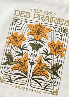 a white shirt with orange flowers on the front and back, says des praires