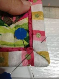 a person is sewing something on a piece of fabric