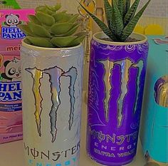 three cans with plants in them sitting on a table