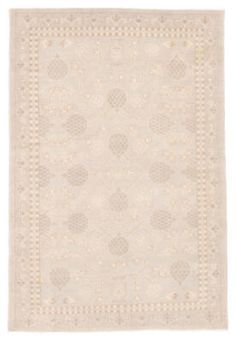 a white rug with an intricate design on the front and back side, in shades of beige