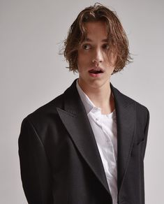 a young man in a black suit and white shirt