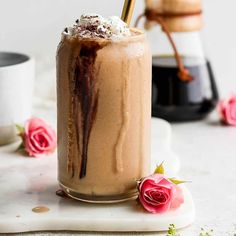 a close up of a drink in a glass with whipped cream and chocolate on top