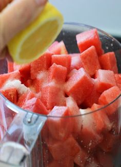 someone is squeezing watermelon into a blender