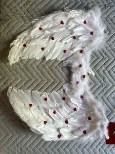 two white feathers with red hearts on them