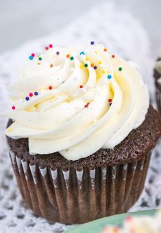 cupcakes with white frosting and sprinkles on a green plate