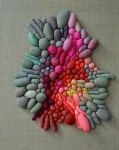 a bunch of rocks are arranged on a table top with the colors of pink, blue, green and yellow