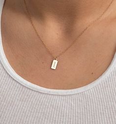 "A sideways display of your name, initials, or a short word makes for an intriguing look with our sleek tag necklace. We will engrave your name or message in vertical display on this 14k gold-filled shiny pendant, that is beautifully complemented by an elegant but understated gold chain. Free Engraving for a limited time! NECKLACE DETAILS ⚬ 14k gold-filled rectangle tag and chain. ⚬ Chain in your choice of 16\", 18\", or 20\" length ⚬ Rectangle measures 13.5mm x 6mm (.53\" x .23\"). ⚬ Spring rin Necklace Engraving Ideas, Minimalist Yellow Gold Initial Nameplate Necklace, Dainty Engraved Nameplate Charm Necklaces, Minimalist Tarnish Resistant Nameplate Necklace, Minimalist Sterling Silver Nameplate Initial Necklace, Minimalist 14k Gold Nameplate Charm Necklace, Minimalist Yellow Gold Nameplate Charm Necklaces, Minimalist Everyday Nameplate Charm Necklace, Minimalist Nameplate Charm Necklace