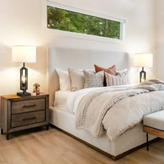 a large bed sitting in a bedroom next to two lamps on either side of it