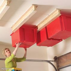 a woman is holding two red bins above her head