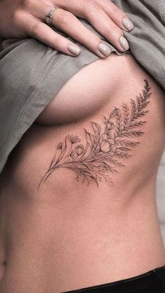 a woman's stomach with flowers and leaves on it