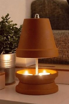 a lamp that is sitting on a table next to a potted plant and some books