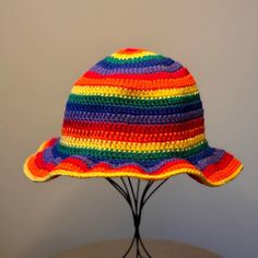 a multicolored crocheted hat sitting on top of a wooden table next to a white wall