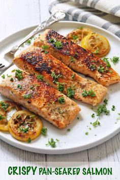 grilled salmon on a white plate with lemons and parsley