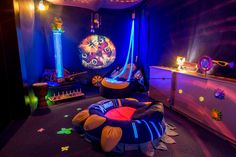 a room filled with lots of toys and decorations on the walls, including an inflatable chair