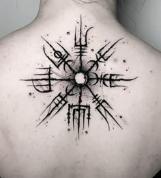 the back of a woman's neck with an abstract tattoo design on her upper