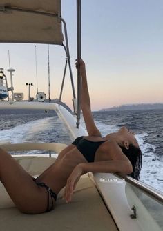 a woman laying on the back of a boat