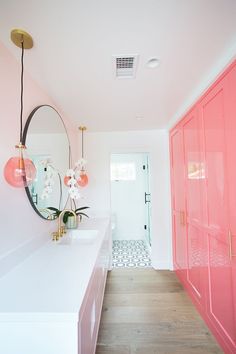 a bathroom with pink cabinets and white walls