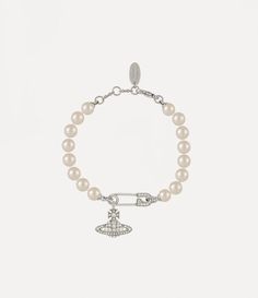 Pearls remain an essential element of the house’s iconography, evoking both a sense of luxury and rebellion. The Lucrece Pearl bracelet features a row of glass-based pearls, complete with a crystal-encrusted orb, dangling from a safety pin charm. Our timeless safety pin details feature as a symbol of non-conformity, reminiscent of Vivienne’s signature punk approach. Luxury Streetwear Jewelry, Vivienne Westwood Charm Bracelet, Vivienne Westwood Bracelet, Channel Outfits, Streetwear Jewelry, Luxe Jewelry, Punk Inspiration, Detailed Jewelry, Jewelry Inspo