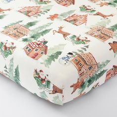 a close up of a bed sheet with christmas decorations on it and santa claus in the house