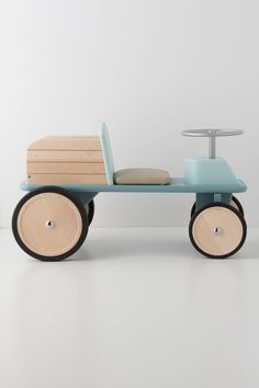 a wooden toy car with wheels and a table on the back that is attached to it