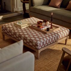 a coffee table with a tray on top of it and candles in front of it