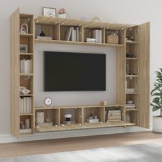 an entertainment center with bookshelves and a flat screen tv mounted on the wall