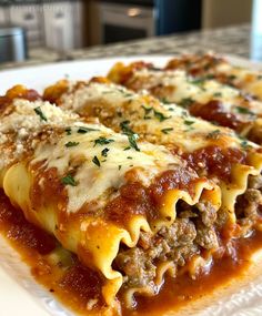 two slices of lasagna on a plate with sauce and cheese, ready to be eaten