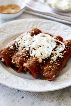 a white plate topped with meat covered in sauce and cheese