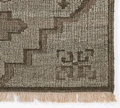 a brown and white rug with fringes on it