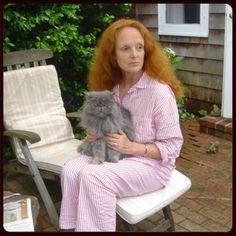 a woman sitting on a bench holding a cat