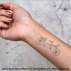 a woman's arm with a tattoo on it that has a bike drawn on it