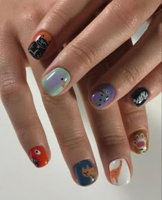 a woman's hand with different nail designs on it, including cats and dogs