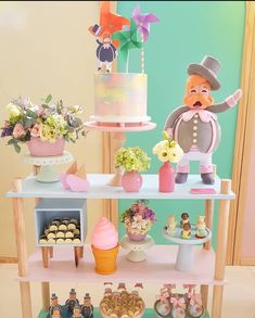 a table topped with lots of cakes and cupcakes