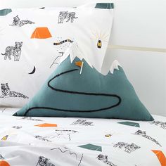 two pillows with animals on them sitting on a bed